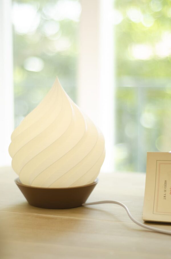 Lampe de table en forme de spirale blanche, imprimée en 3D avec un matériau recyclable.