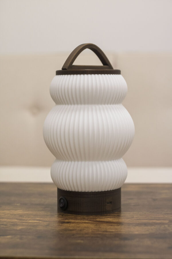 Lampe rechargeable au design élégant avec base en bois, port USB-C et poignée intégrée.