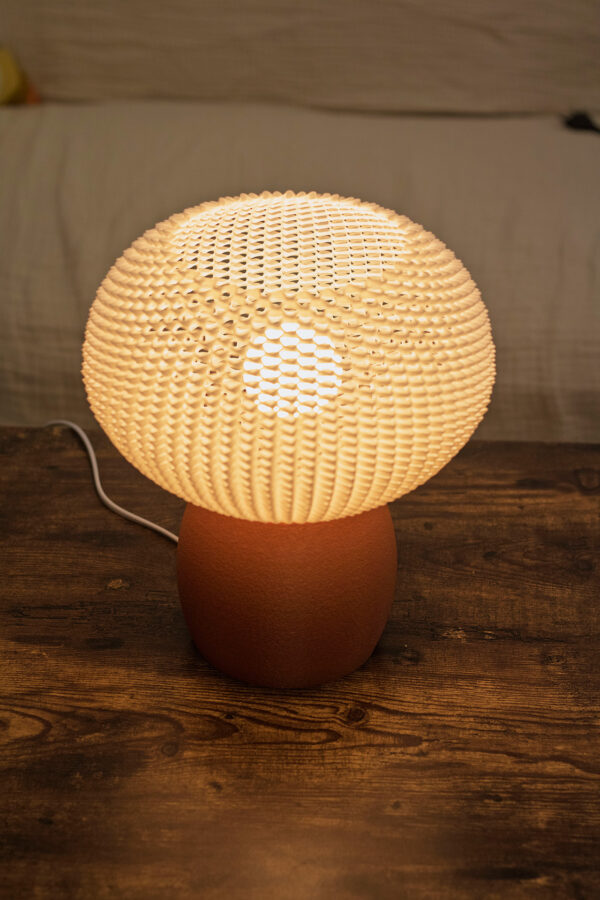 Lampe BULO en impression 3D avec un abat-jour ajouré blanc diffusant une lumière douce.